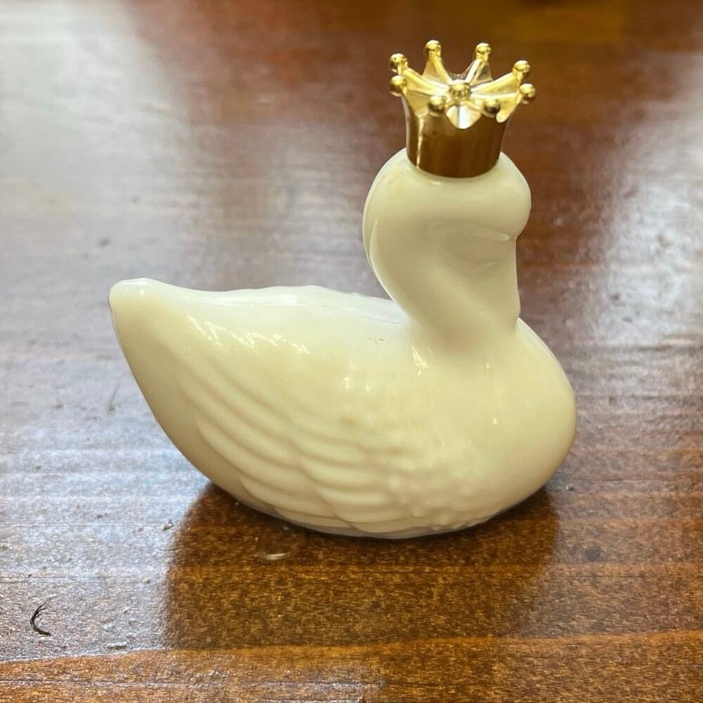 This 1970s Avon "Royal Swan" decanter milk glass w/ iconic gold crown stopper